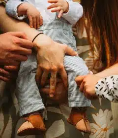 a group of people holding a baby in their hands